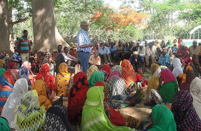 Ato Ahmed umgeben von Menschen die auf Hilfe in Form von Saatgut hoffen.